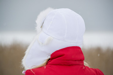 Woman Wearing a White Hat and Red Jacket Outdoors in Winter