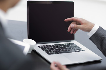 closeup. business colleagues discussing information with a laptop.