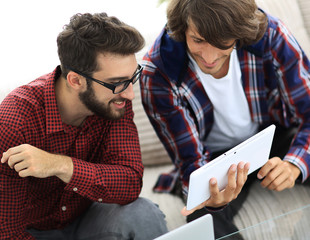 two creative web designers working with a tablet and a laptop.