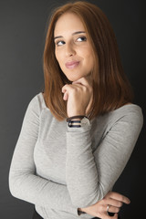 Portrait of a red hair young girl on black background. Half length.