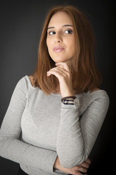 Portrait of a red hair young girl on black background. Half length.