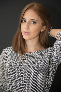 Portrait of a red hair young girl on black background