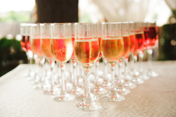 A lot of wine glasses with a cool delicious champagne or white wine at the bar. Alcohol background.