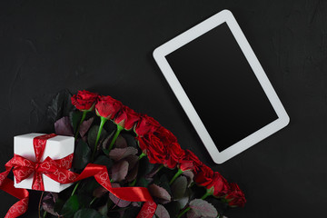 Top view fresh red rose flower and gift box on black deck with empty space for design. For love or valentine day concept