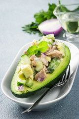 Tuna avocado salad boats on concrete background. Selective focus, copy space. 