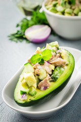 Healthy tuna avocado boats on concrete background. Selective focus, copy space.