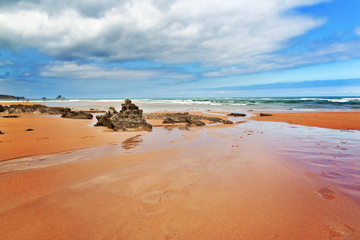 Strip of big stones on the sandy beach during an outflow