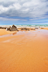 Strip of big stones on the sandy beach during an outflow