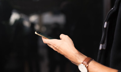 Close up young man using cellphone outdoors for online social connection