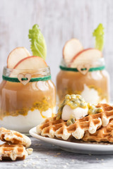 Wafers with cream watered passion fruit. In glass jars, yogurt with apple juice and a green leaf.