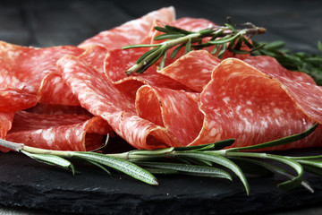 Stone cutting board with sliced salami on it