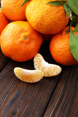 Tangerines with leaves on wooden background. Mandarins Rustic style.