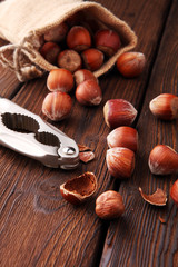 Hazelnut with peeled hazelnuts in burlap on textured wooden background