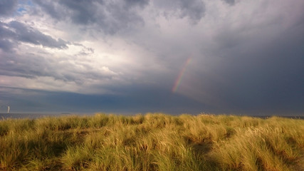 Fototapeta na wymiar Rainbow and dramatic sky at the beach in Copenhagen - Amager