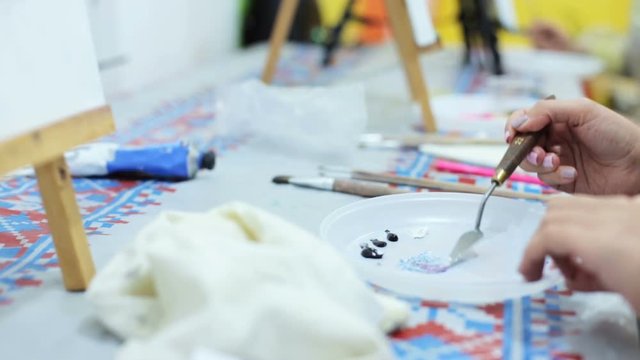 Young artist mixes oil paints