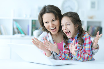 mother and daughter using laptop