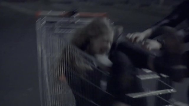 Young couple rolls in a shopping cart