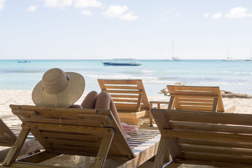 Fototapeta na wymiar Girl with hat, chaise lounges, beach, sea