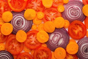 Colorful slices of tomatoes, carrots and onion