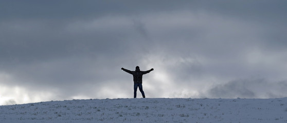 Mann steh am Horizont auf verschneiten Feld