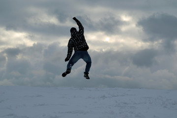 Mann springt am Horizont freudig in die Luft