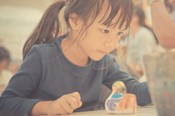 Student is painting a doll in art classroom