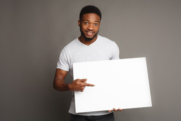 Picture of young african-american man holding white blank board