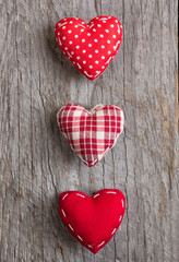 Three red hearts on wooden surface