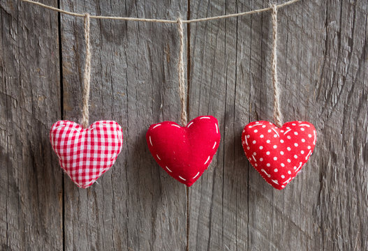 Three hearts hanging on wooden surface