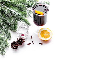 Warm mulled wine with citrus and spices for winter evening near spruce branch on white background copyspace