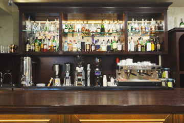 Bar counter with alcohol bottles assortment - obrazy, fototapety, plakaty