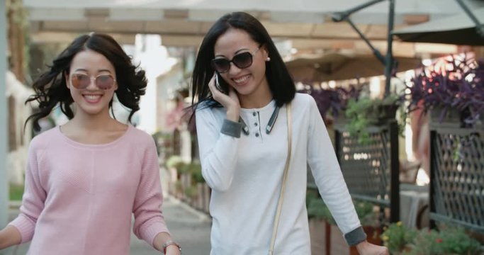 close-up of two Asian girls attractive girls after a day of shopping with a cheerful mood outdoor