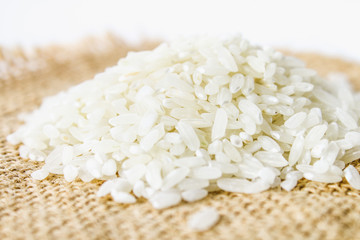 Grains of raw white rice on a white wooden table of boards. Ingredients for cooking.