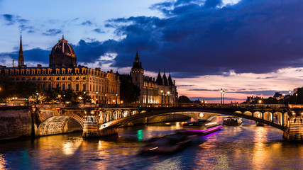 Fototapeta na wymiar Night view of Conciergerie Castle and Pont Notre-Dame bridge over river Seine. Paris, France