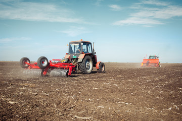 Tractor with a roller on the field at spring