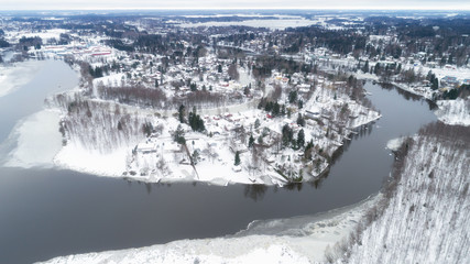 Fototapeta na wymiar Aerial view of the village and river at winter. The streets are covered with snow. Lempaala