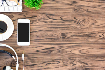 Brown wood office desk table and equipment for working and listening music with white headphone in top view and copy space.