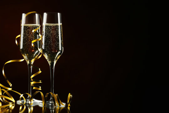 Champagne glasses with ribbon on black background