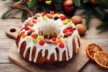 Bundt cake with dried oranges on cutting wooden board