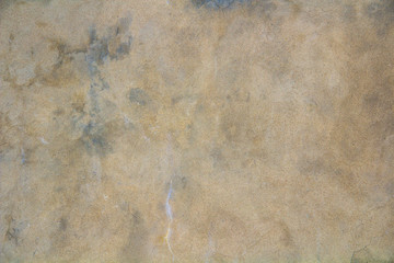 The texture of a dirty concrete wall with spots and cracks.