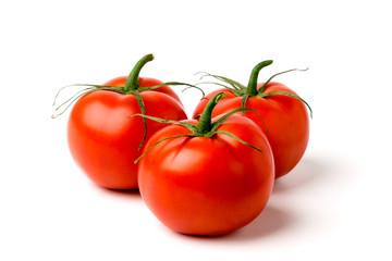 Three ripe tomatoes on a white