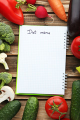Blank diet menu on paper with vegetables on wooden table
