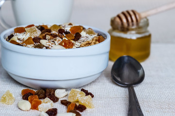 Healthy eating. On the wooden board are muesli, a spoon, a glass of milk, a jar of honey.