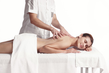 Fototapeta na wymiar Professional masseur doing massage of female back in the beauty salon