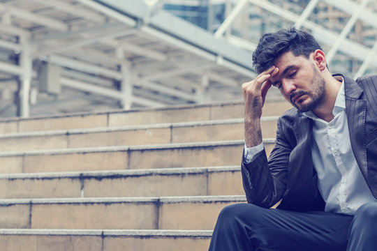 Unemployed businessman stress sitting on stair, concept of business failure and unemployment problem, work life balance.