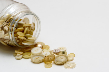 Beige buttons in a jar on white background isolated