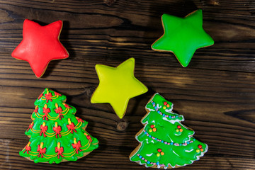 Festive Christmas gingerbread cookies in the shape of Christmas tree and stars on wooden table. Top view