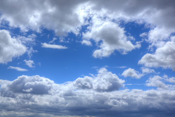 White clouds in the blue sky on a sunny day.