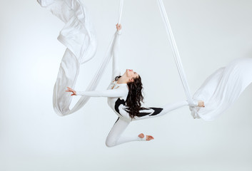Aerial artistic acrobatics, a woman demonstrates poses.