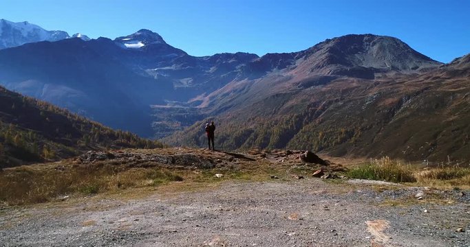Woman and child, Cinema 4k aerial view over a mother and a kid, standing on a mountain ledge, on a sunny fall day, on simplon pass, in wallis, of the alps in Switzerland